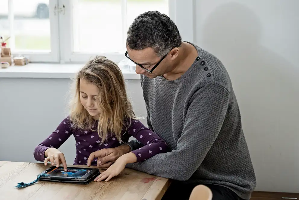 En voksen og et barn med en iPad.